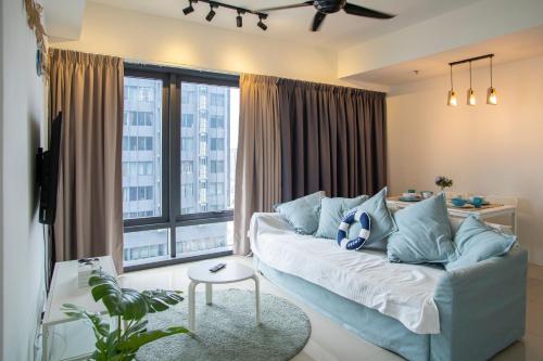 ein Wohnzimmer mit Couch und großem Fenster in der Unterkunft Tropicana 218 MACALISTER in George Town