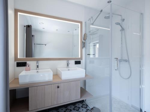 a bathroom with a sink and a mirror and a shower at Vakantiewoning Mierzicht met privé wellness in Gingelom