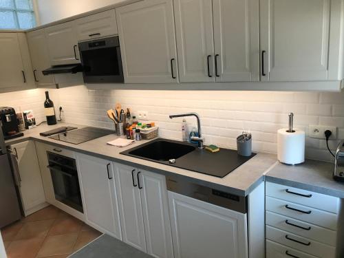 a kitchen with white cabinets and a sink at Appartement 3 chambres proche mer et Negresco in Nice