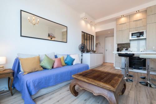 un salon avec un canapé bleu et une table dans l'établissement Sea View - Promenade des Anglais 1 Bdr, à Nice