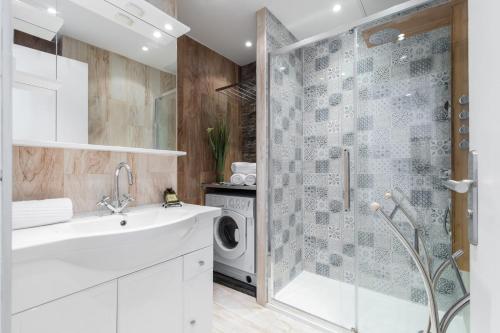 une salle de bain avec un lavabo et une machine à laver dans l'établissement Sea View - Promenade des Anglais 1 Bdr, à Nice