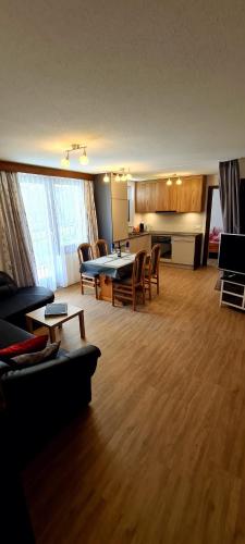 sala de estar amplia con mesa y sillas en Apartmenthaus Sunshine, en Saas-Grund
