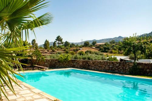 a swimming pool in a villa with mountains in the background at Quintinha Viçosa in Aldeia Viçosa