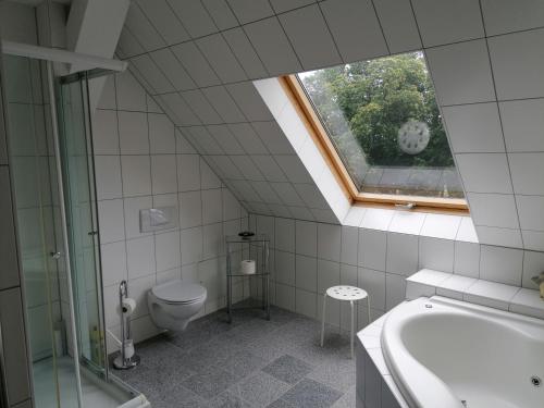 La salle de bains est pourvue de toilettes, d'une baignoire et d'une fenêtre. dans l'établissement Schloß Wichmannsdorf, à Kröpelin
