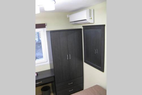 a kitchen with two black cabinets and a microwave at Little House Ligia in Lygia