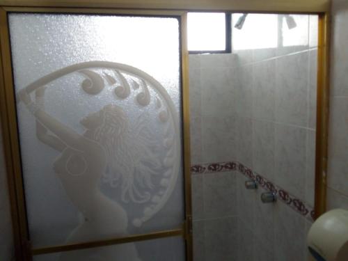 a bathroom with a shower with a woman on the glass at Hotel International Prestige in Ambato