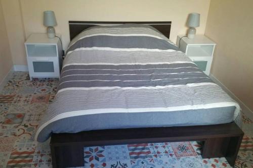 - un lit dans une chambre avec 2 tables de nuit dans l'établissement L'appart, à Grandcamp-Maisy