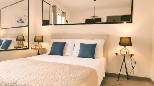 a bedroom with a white bed with blue pillows at Central Park Suites in Vodice