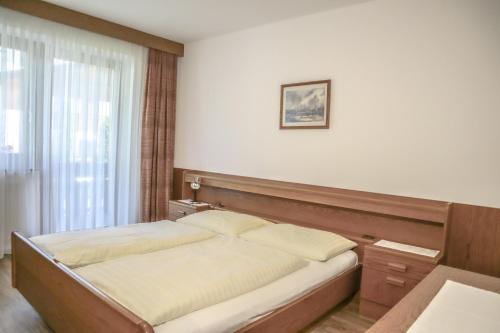 ein Schlafzimmer mit einem Bett in einem Zimmer mit einem Fenster in der Unterkunft Pension Ridnauntal in Ratschings
