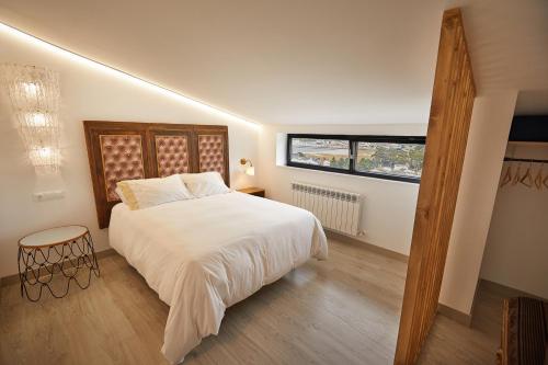 um quarto com uma cama branca e uma janela em Ático con maravillosas vistas em Viveiro