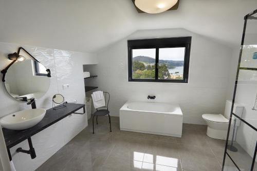 a bathroom with a sink and a tub and a mirror at Ático con maravillosas vistas in Viveiro