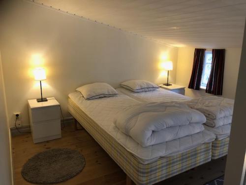 1 dormitorio con 1 cama grande y 2 lámparas en Gårdshuset en Söderköping