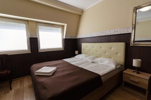 a bedroom with a large bed with two windows at Bella Villa in Siófok