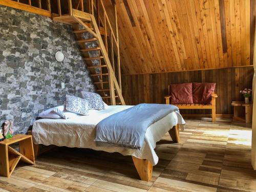 a bedroom with a bed and a wooden wall at Tityra Lodge in Monteverde Costa Rica
