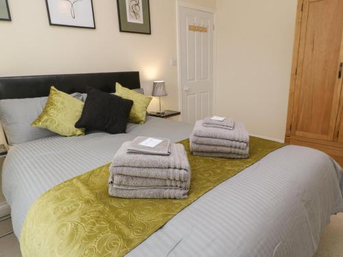 a bedroom with a bed with towels on it at Nappers Cottage in Hayle