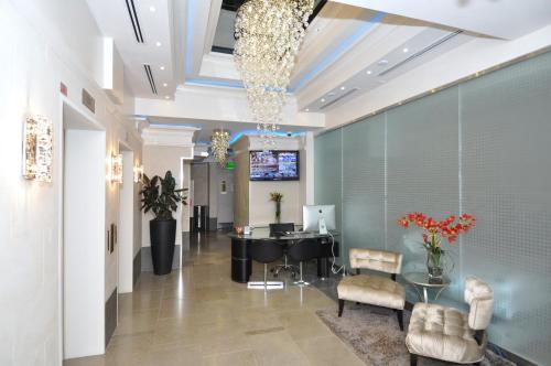 a lobby with a waiting room with a table and chairs at Yonge Suites Apart Hotel in Toronto