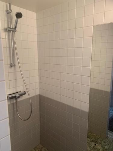 y baño con ducha con cabezal de ducha. en Gårdshuset en Söderköping