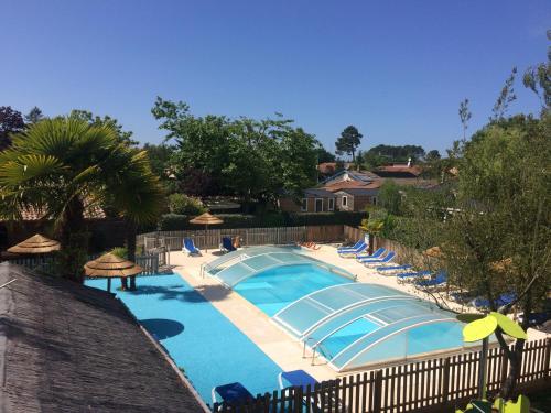 a large swimming pool with chairs and umbrellas at La Cabane d'Arès - chambre double PREMIUM in Arès
