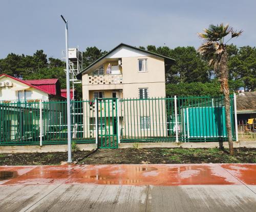 a green fence in front of a house at Ureki House in Ureki