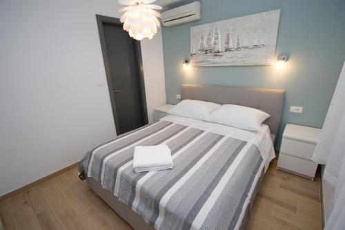 a small bedroom with a bed with a striped blanket at Apartment Ana Bratus in Baška Voda
