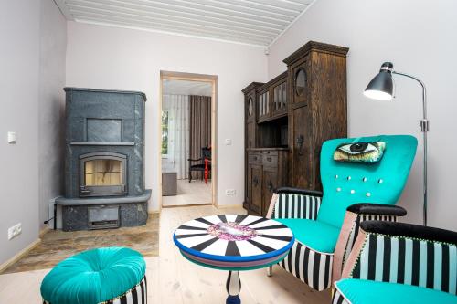 a living room with a fireplace and a green chair at Lakeview beach apartment in Viljandi in Viljandi