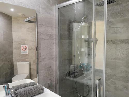 ein Bad mit einer Dusche, einem WC und einem Waschbecken in der Unterkunft Playa Flores Deluxe - Vistas a la piscina in Torremolinos