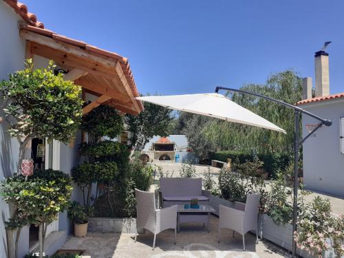 a patio with a table and an umbrella at Vasiliki Residence in Pylos