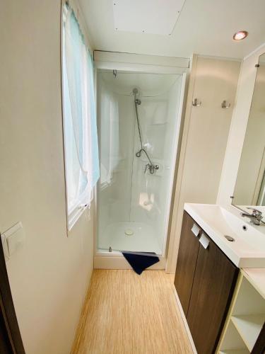une salle de bain avec douche et lavabo dans l'établissement Mobilhomes de Pierrot, à Argelès-sur-Mer