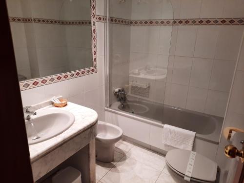 桑克森克索的住宿－Hotel Cervantes，一间带水槽、浴缸和卫生间的浴室