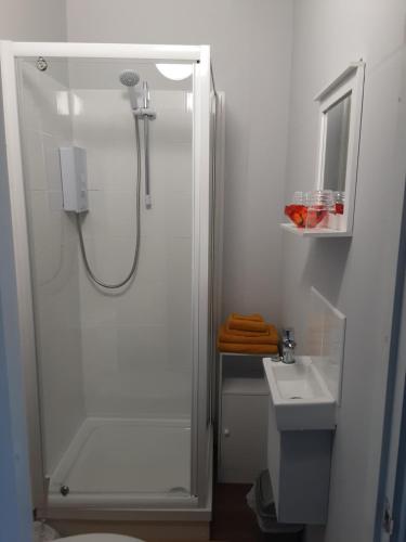 a white bathroom with a shower and a sink at Atlantic cottage in Blackpool