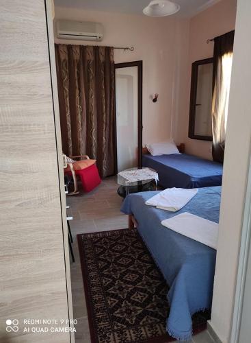 a hotel room with two beds and a window at Aktaion in Milina
