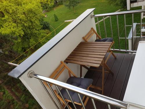 a balcony with a wooden table and chairs at MarSim Lux apartman Zagreb in Zagreb