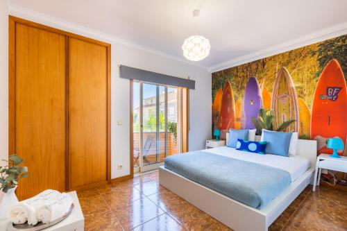 Aguda Beach Apartment في Arcozelo: غرفة نوم مع سرير كبير مع ألواح ركوب الأمواج على الحائط