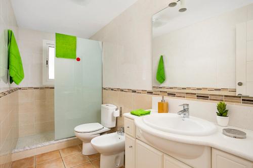 a bathroom with a sink and a toilet and a mirror at Villa Menorca Raquel by Mauter Villas in Cala en Bosc
