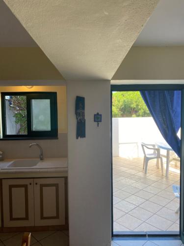 une cuisine avec un évier et une vue sur un patio dans l'établissement Casa Salina, à Santa Marina Salina