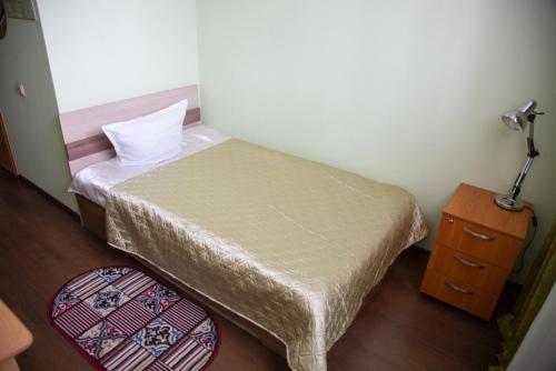 ニジニ・タギルにあるHotel Malakhitovayaの小さなベッドルーム(ベッド1台、ナイトスタンド付)