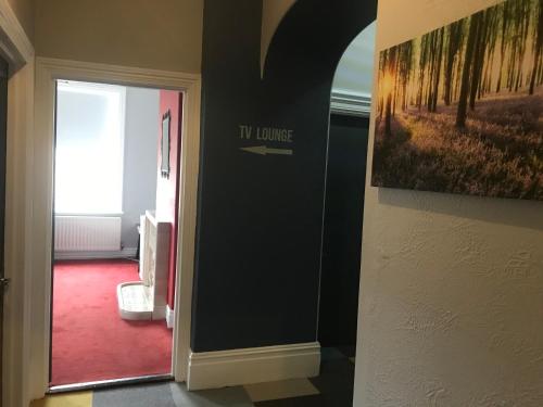 a hallway with a tv lounge sign on a wall at Newcastle House Rothbury in Rothbury