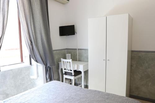 罗马Guest House Relais Indipendenza的一间带床、书桌和电视的卧室
