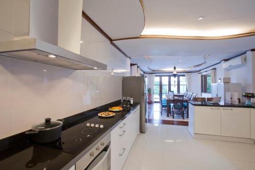 a kitchen with a stove and a counter top at Paradise Island Estate in Choeng Mon Beach
