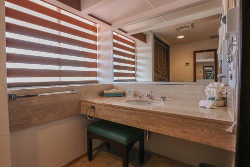 a bathroom with a sink and a mirror at The Royal Cancun - All Suites Resort in Cancún