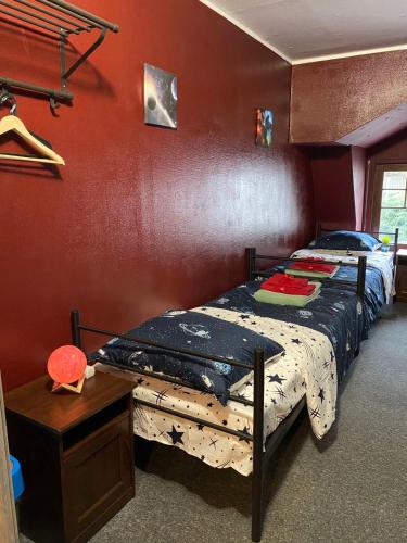 a bedroom with a bed and a red wall at Hostel Galaxy in Gdańsk