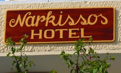 a sign on a building with a plant on top of it at Narkissos Hotel in Kamari