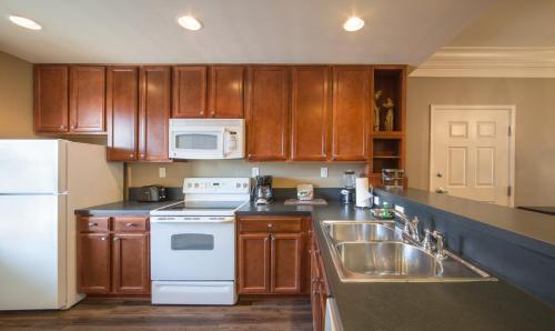 a kitchen with wooden cabinets and a white refrigerator at Holiday Inn Club Vacations Williamsburg Resort in Williamsburg