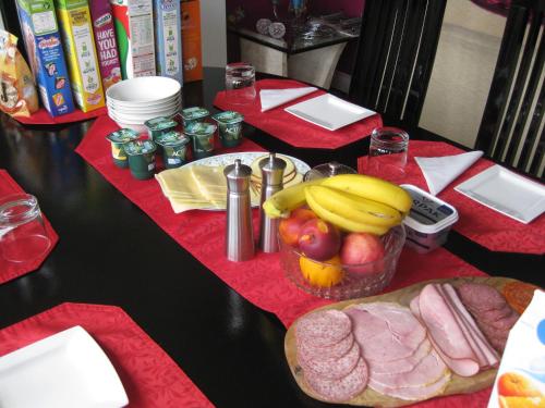 a table with a bowl of fruit and a plate of food at Brooklyn House in Barnet