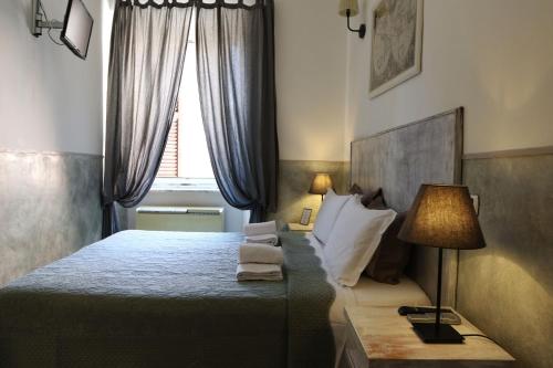 罗马Guest House Relais Indipendenza的一间卧室配有一张带灯和窗户的床