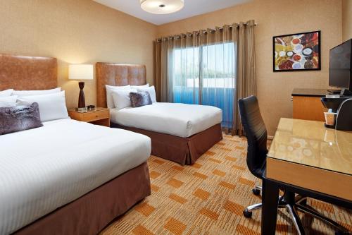 una camera d'albergo con 2 letti e una scrivania di Elan Hotel a Los Angeles