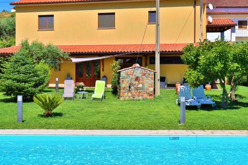 une maison avec une cour dotée de chaises et d'une piscine dans l'établissement Casa Cova do Barro, à Janeiro de Cima