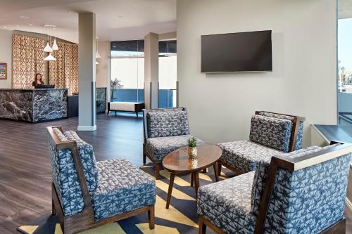 a lobby with chairs and a table and a tv at Elan Hotel in Los Angeles