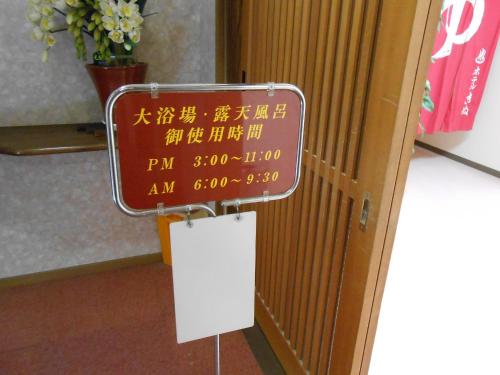 a sign in front of a door in a room at Hotel Kinu in Nikko
