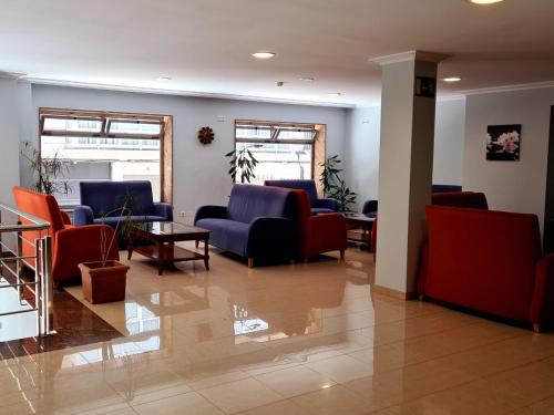 a waiting room with couches and chairs and a table at Hotel Europa in Cambados